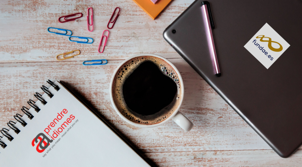 formació d'idiomes per a empreses a través de Fundae. llibreta cafè laptop i clips