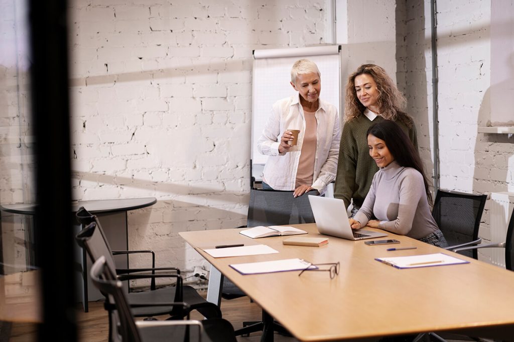 Sesión de formación de idiomas para empresas con un equipo trabajando alrededor de un portátil.