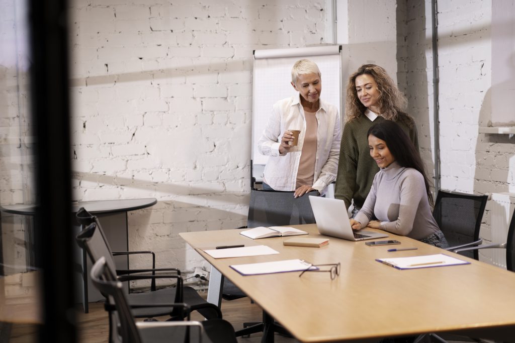 Sesión de formación de idiomas para empresas con un equipo trabajando alrededor de un portátil.